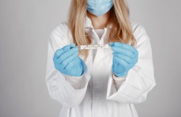 doctor wearing a medical mask holding an STI testing theme isolated white background