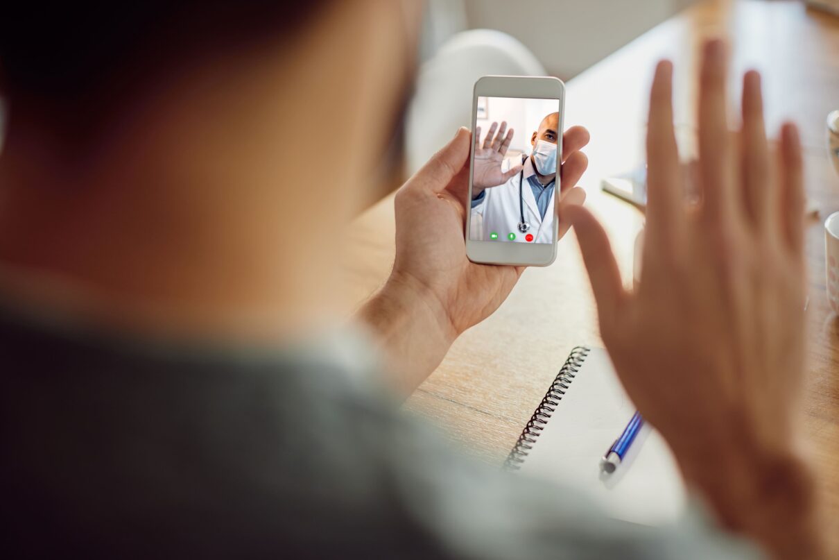 closeup african american doctor greeting his patient video call mobile phone on a telehealth continuity care session