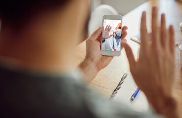 closeup african american doctor greeting his patient video call mobile phone on a telehealth continuity care session
