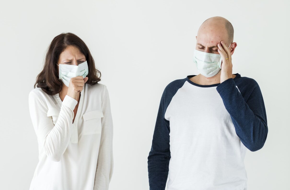 sick couple wearing surgical mask to present the flu vs COVID symptoms